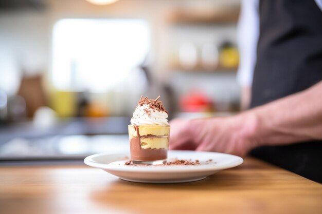 Hand holding chocolate mousse cup blurred kitchen background