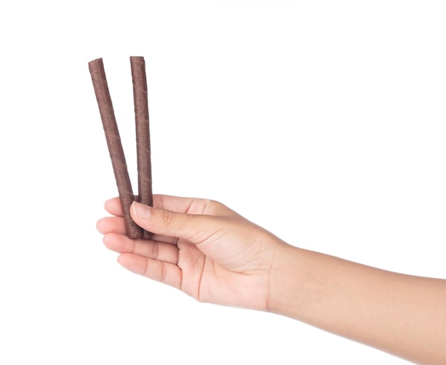 Photo hand holding chocolate wafer sticks isolated on white background.