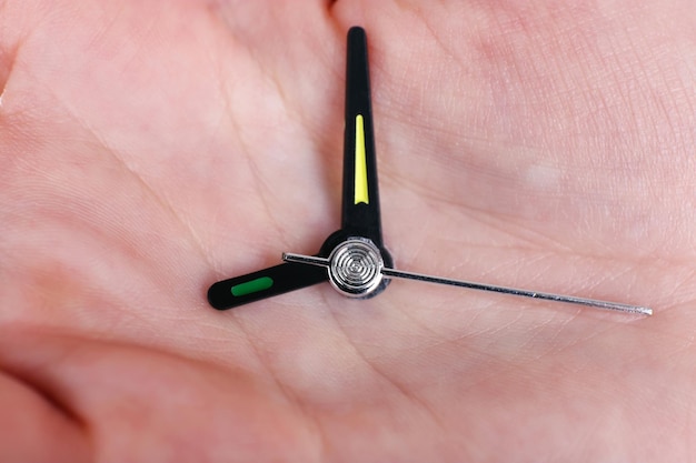 Hand holding clock arrows close up