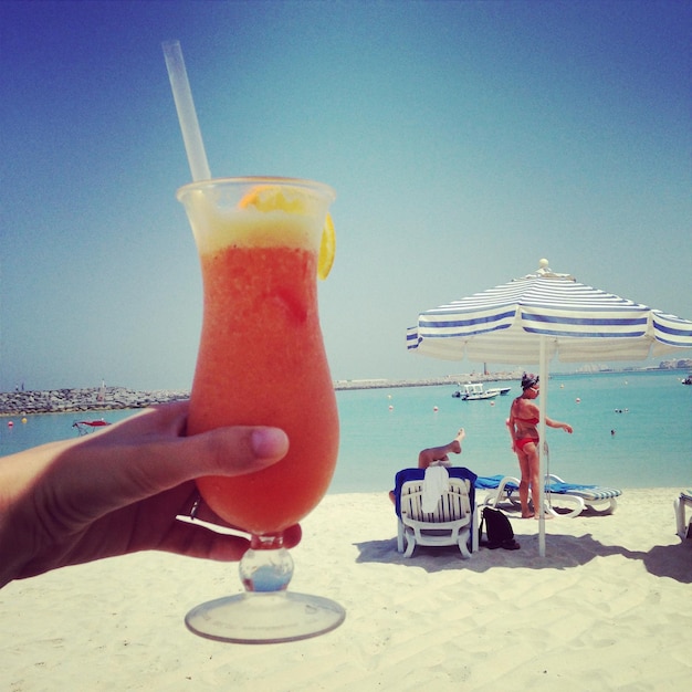 Foto un cocktail a mano sulla spiaggia