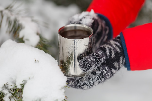 屋外のコーヒーカップを持っている手