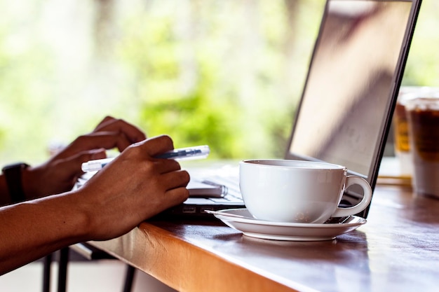 Hand holding coffee cup on table