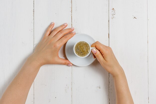 Hand holding coffee cup on white background