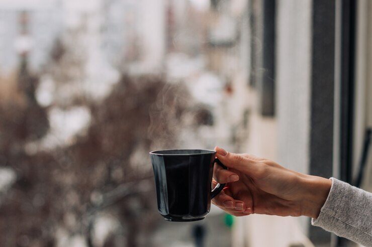 Photo hand holding coffee outise