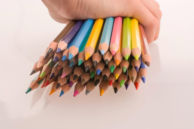 Hand holding Color pencils on a white background