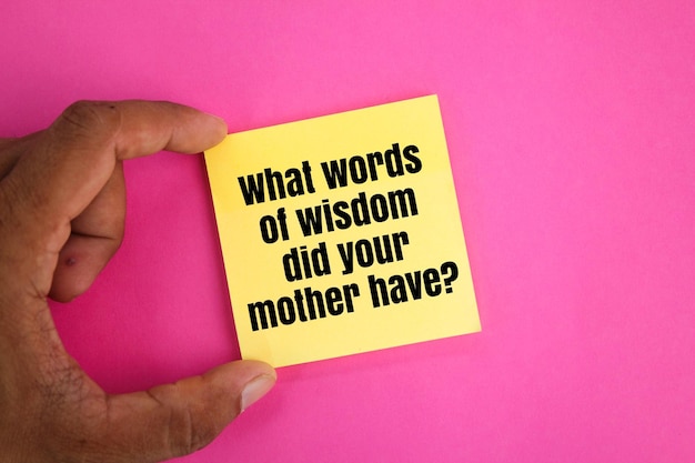 Photo hand holding colored paper with question words what words of wisdom did your mother have