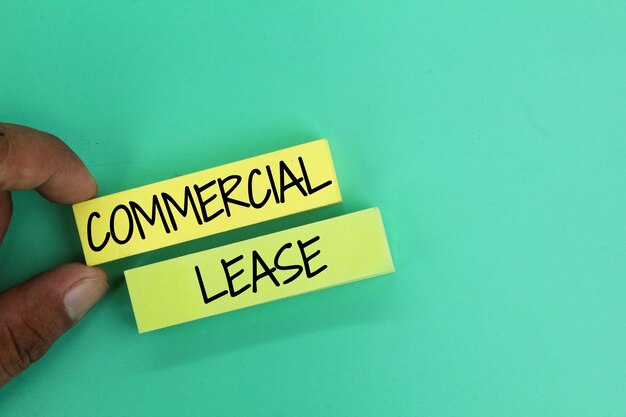 hand holding colored paper with the word commercial lease A form of legally binding contract made