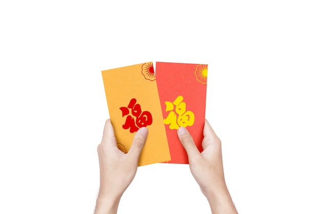 白い壁に隔離されたカラフルな封筒（Angpao）を持っている手