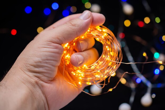 Hand holding Colorful glowing fairy light Holiday festive xmas decoration Christmas lights