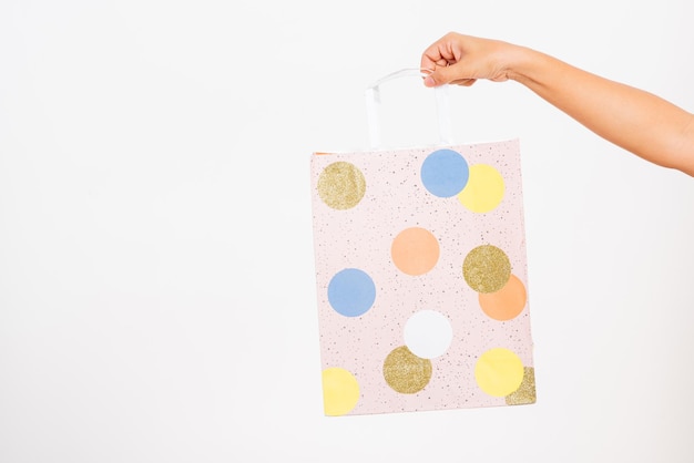 Hand holding a colorful pink shopping bag circular pattern