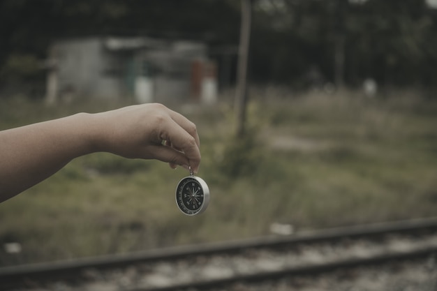 Hand holding a compass for finding travel destinations. Vintage style.