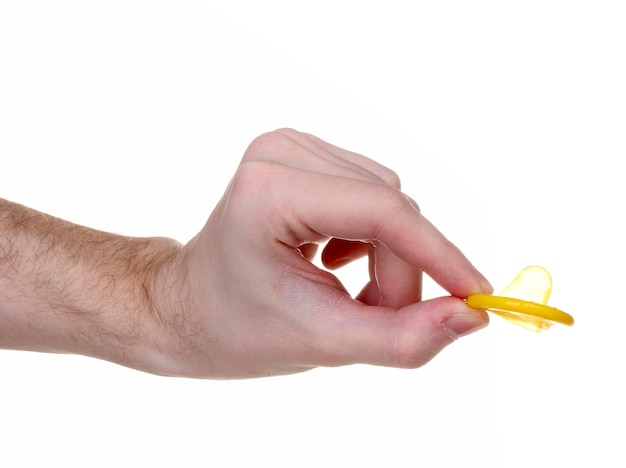 Hand holding a condom isolated on white