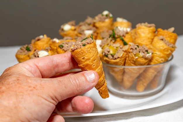 A hand holding a cone of food with the word cheese on it