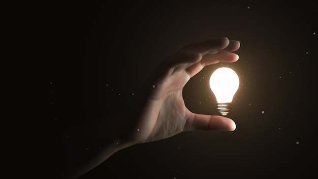 Hand holding creative idea electric light bulb or glowing\
inspiration lightbulb invention power and success business thinking\
lamp symbol isolated on black background with innovation\
achievement goal.