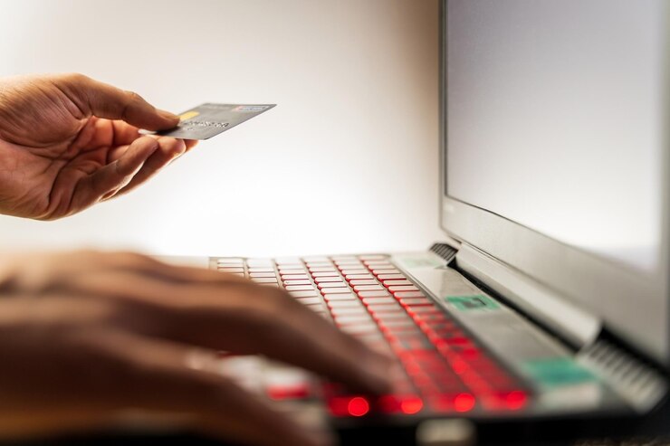 Photo hand holding credit card mock up while type payment information on laptop for online purchase