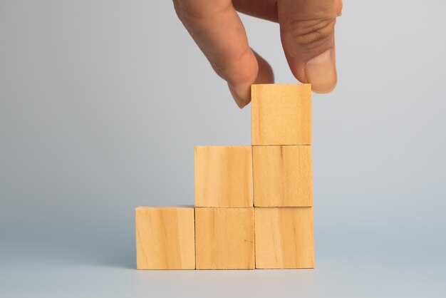 Hand holding cube wood block blank on background copy space