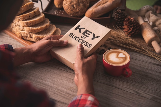 Hand holding a cup of coffee and reading a book key of success - concept lifestyle