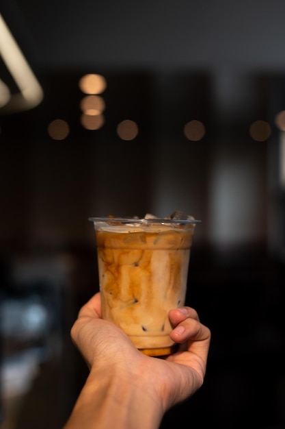 A hand holding a cup of iced coffee