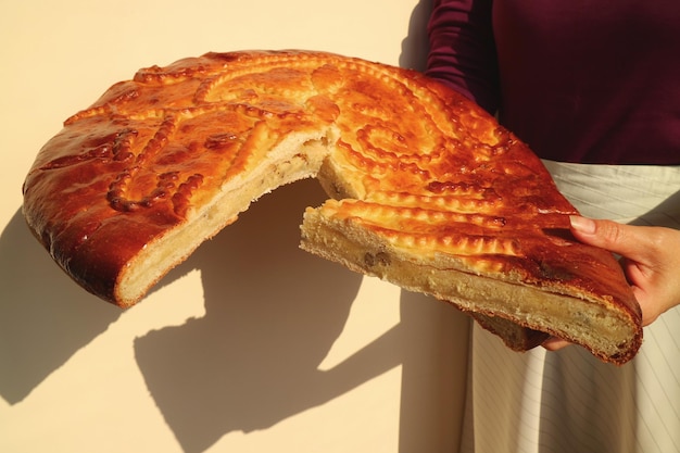 Hand Holding Cut Armenian Traditional Bread Called Gata Showing Its Sweet Filling with Walnuts