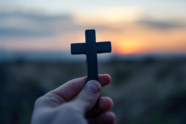 hand holding a dark wooden cross against a softly lit background