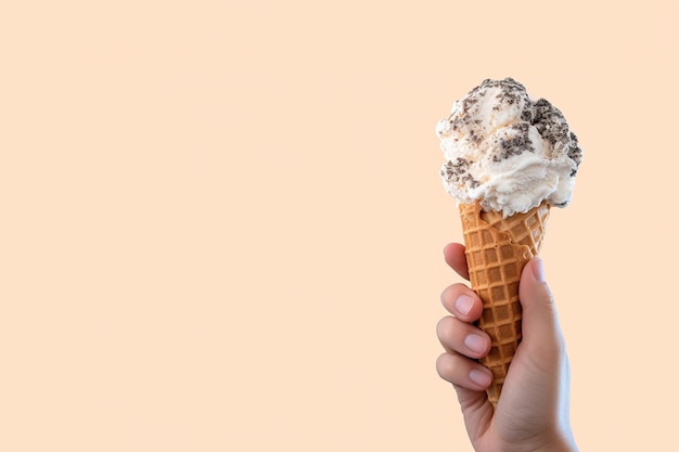 Hand holding delicious cookies and cream ice cream in a crispy waffle cone with copy space