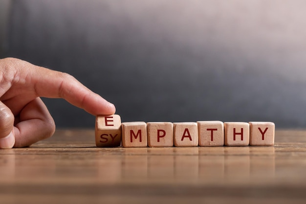 hand holding dice with text for illustration of EMPATHY and SYMPATHY words