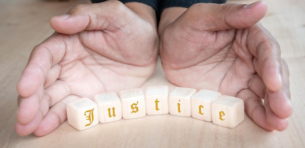 hand holding dice with text for illustration of JUSTICE words