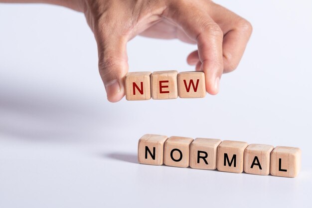 hand holding dice with text for illustration of NEW NORMAL words