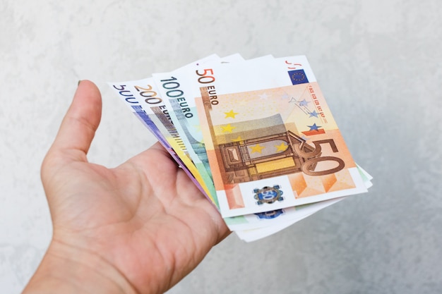 Hand holding different new euro banknotes.