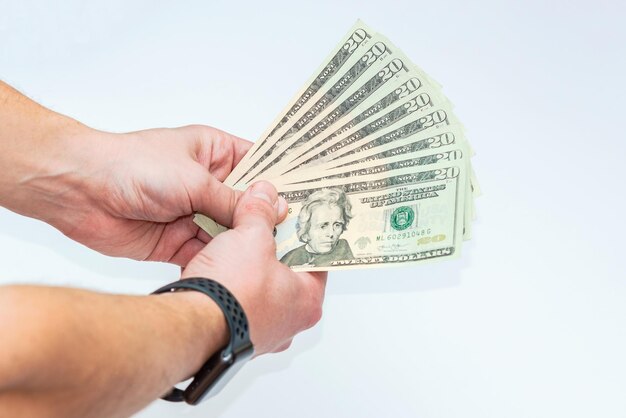 Hand holding dollars on white backgrounds. Isolated