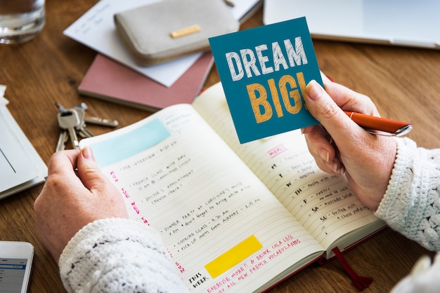 Photo hand holding dream big wording on a sticky note