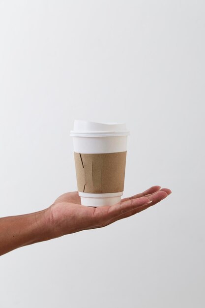 Hand holding drink against white background