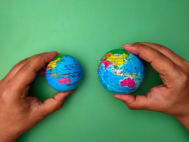 Hand holding earth globe on a green background