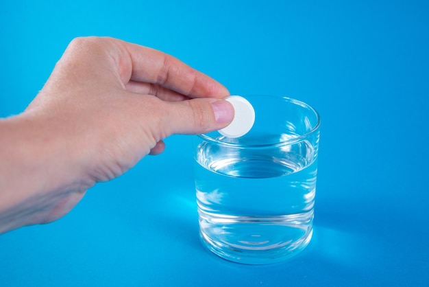 A hand holding effervescent soluble calcium tablet or vitamin C