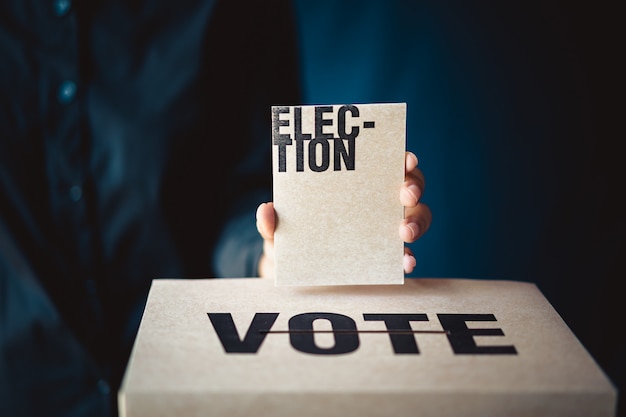 Photo hand holding election card and vote box, democracy concept, retro tone