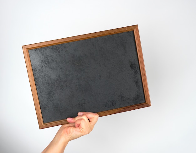 Hand holding an empty wooden chalk frame on gray