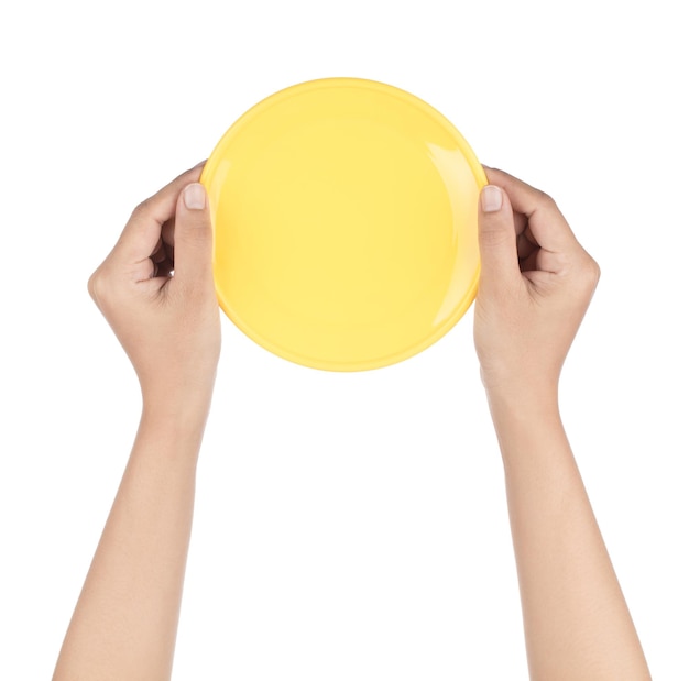 Photo hand holding empty yellow plastic plate isolated on white background