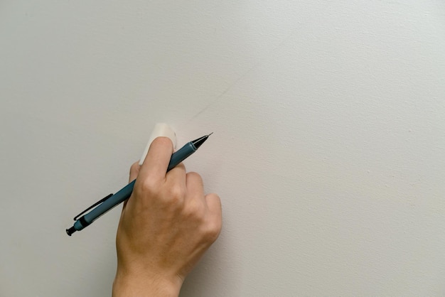 hand holding eraser and clutchtype pencil with canvas background