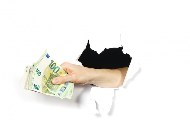 Hand holding euro banknotes through a hole