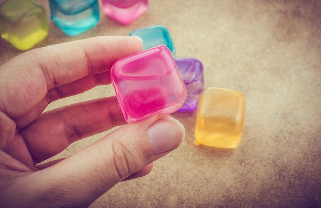 Hand holding a fake colorful ice cube