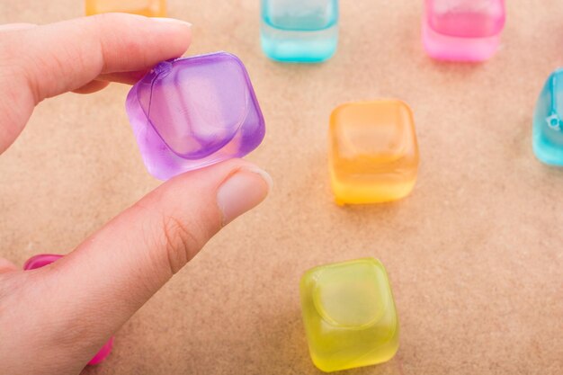 Hand holding a fake colorful ice cube