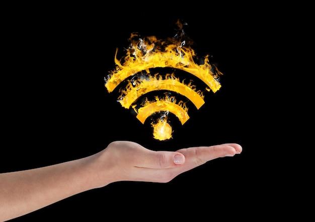 Hand holding fiery wifi symbol over black background