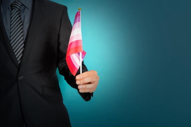 Hand holding flag in lesbian pride colors