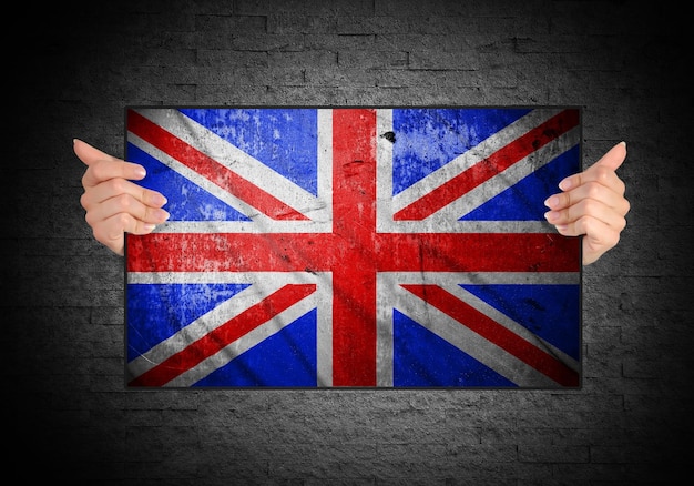 Hand holding flag of United Kingdom