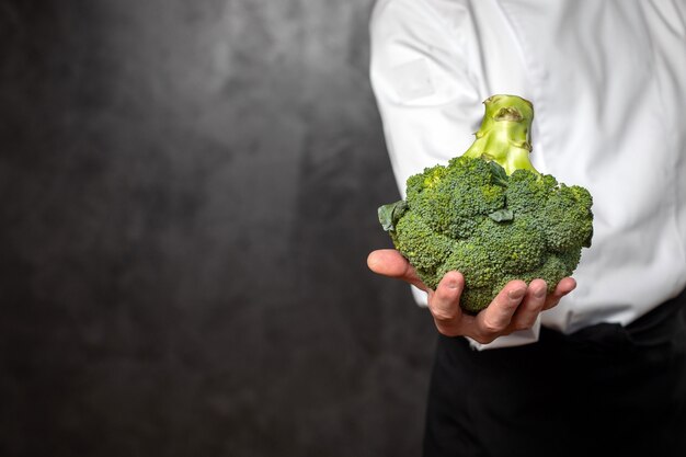 hand holding a floret of broccoli