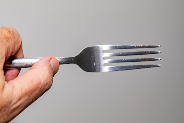 A hand holding a fork with the number 3 on it