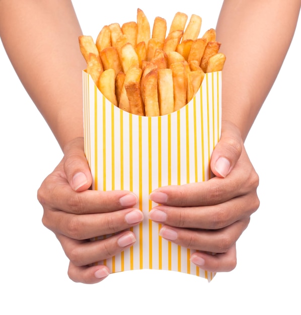 Hand holding French fries in a yellow paper bag isolated on a white background