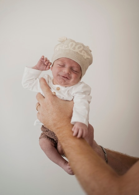 Foto mano che tiene piccolo bambino divertente