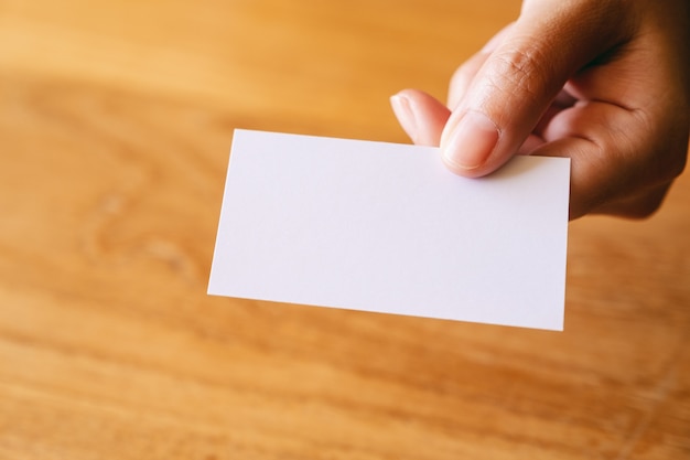 A hand holding and giving empty business card