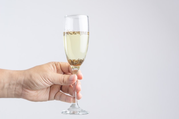 Mano che tiene un bicchiere di champagne con parassiti o insetti